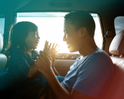 Father and daughter playing and laughing together in a car.