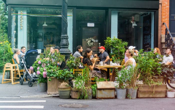 New Yorkers eating outdoors at a restaurant.